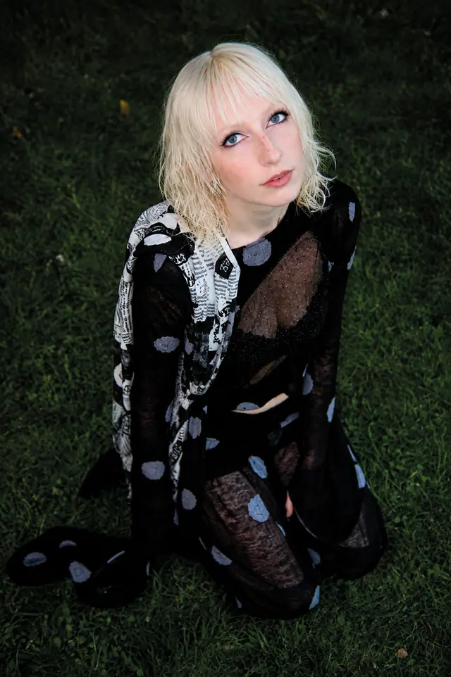 Amulette: Model kniend im Gras