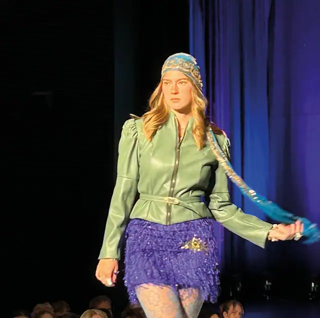 Laufsteg: Model in grüner Jacke und blauem Rock